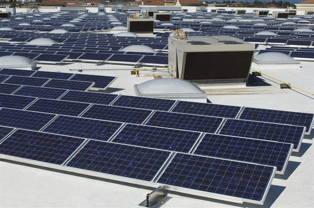 Array of solar panels on roof with exhaust fan