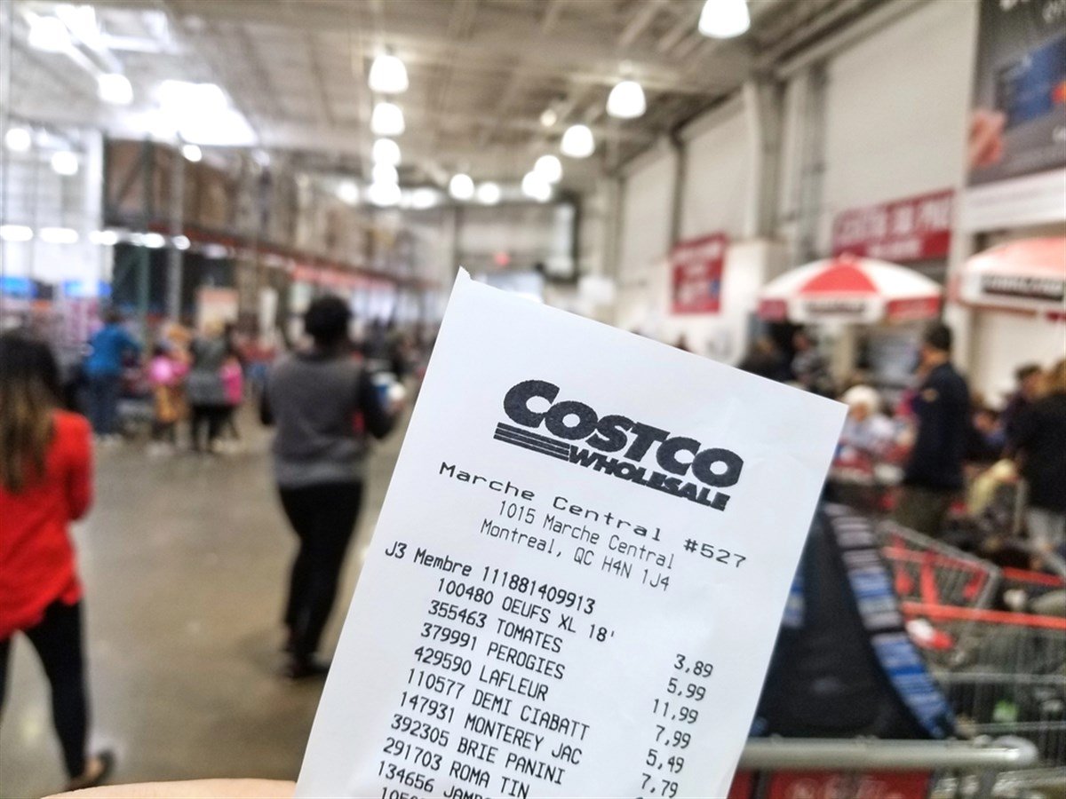 MONTREAL, CANADA - OCTOBER 5, 2018: A hand holding a receipt with the brand name and logo in Costco warehouse. Costco is an American corporation which operates a chain of membership only warehouses. — Stock Editorial Photography