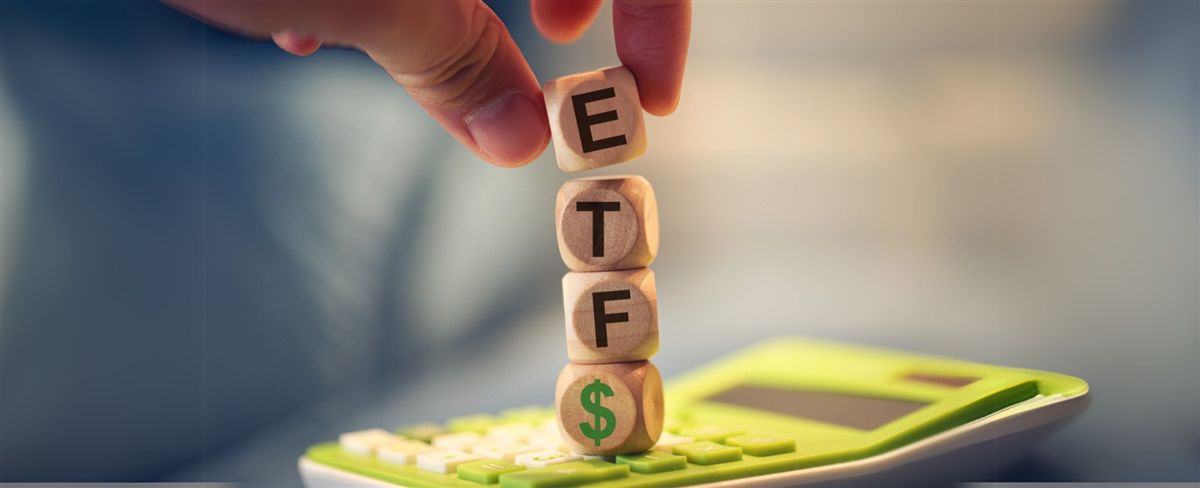 Close-up view of man forming acronym ETF with wooden cubes. A calculator in the composition. — Photo