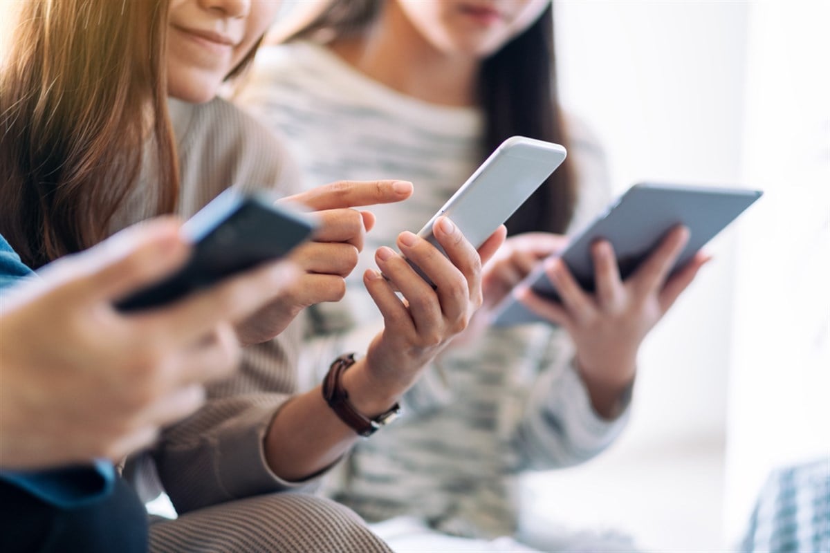 Group of people using and looking at mobile phone and tablet pc while sitting together