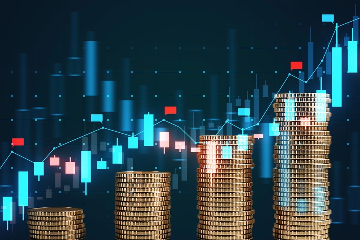 Stacks of gold coins in the foreground with a digital financial chart background. The concept of market growth, investing, trading, and finance is depicted — Photo