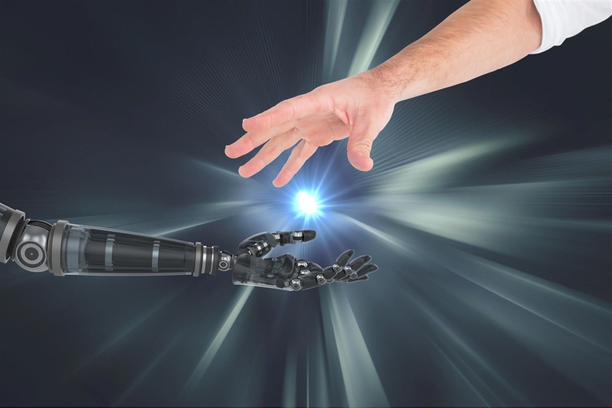 Photo illustrating the connection between human and robot hand against silver background