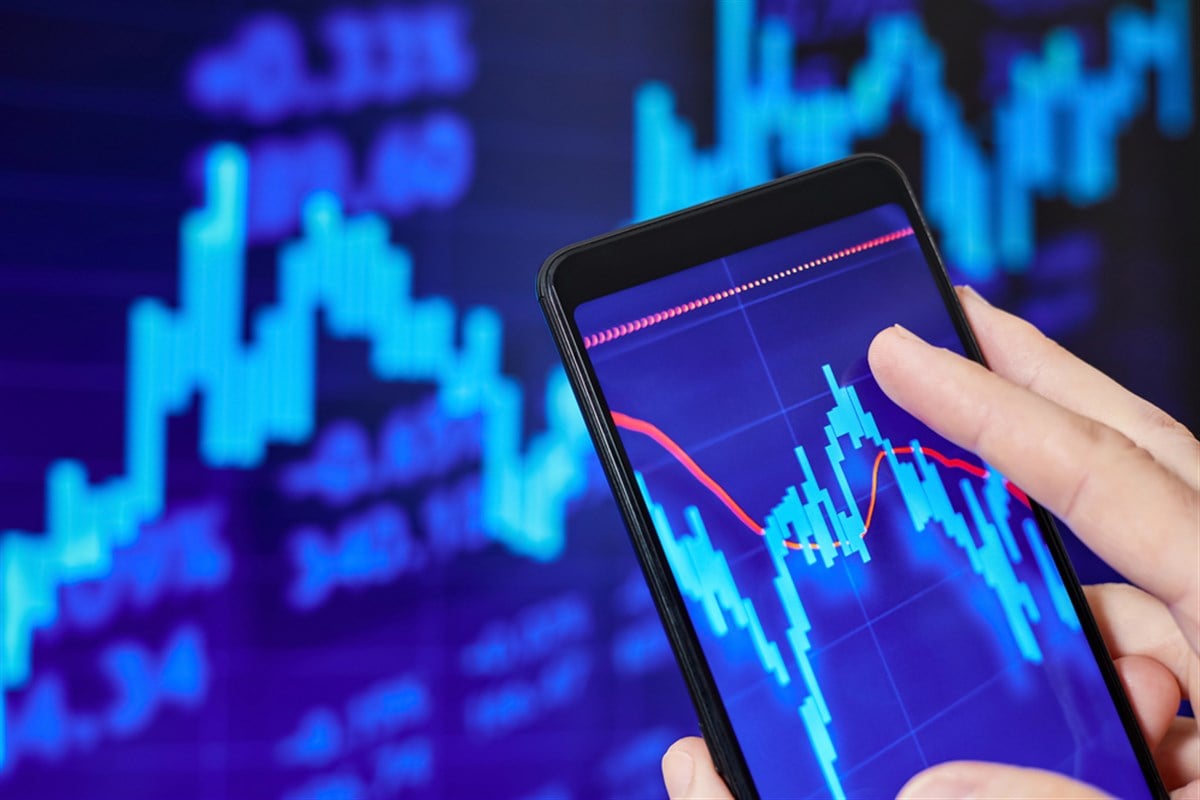 Trader analyzes stock market data in smartphone - stock image