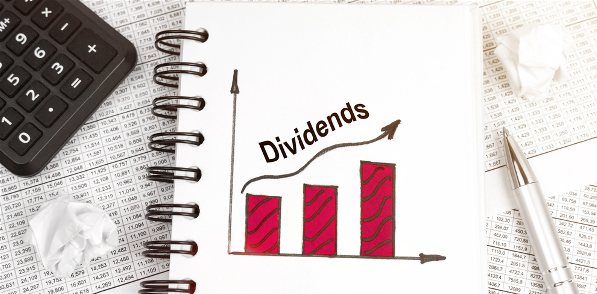 Business and finance concept. On the table is a calculator, a pen and a notebook with a graph and an inscription - Dividends — Photo