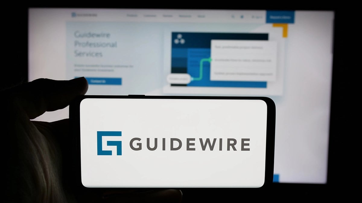 Stuttgart, Germany - 11-14-2024: Person holding cellphone with logo of US company Guidewire Software Inc. on screen in front of business webpage. Focus on phone display. — Stock Editorial Photography