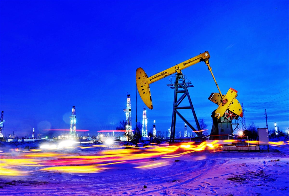 Night view of an oil derrick pumping crude oil at an oil field in Daqing, northeast Chinas Heilongjiang province, 17 December 2009. — Stock Editorial Photography