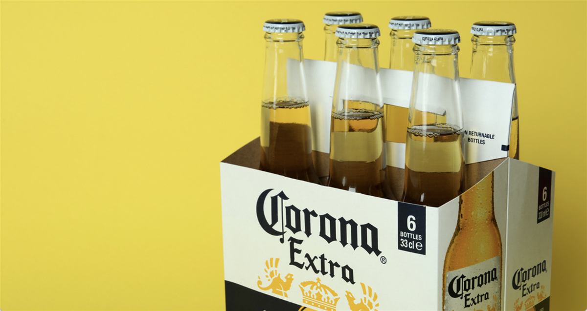 Carton box with Corona Extra on yellow background — Photo