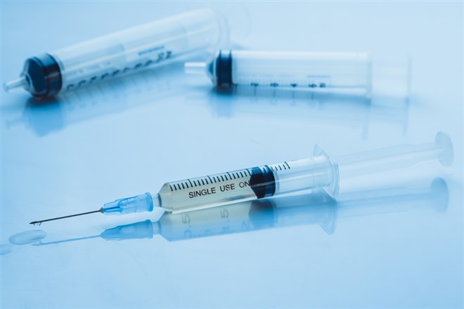 Used medical syringes on blue tone