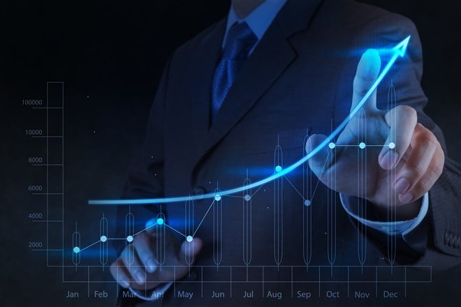 closeup of male hand touching chart showing stock price growth