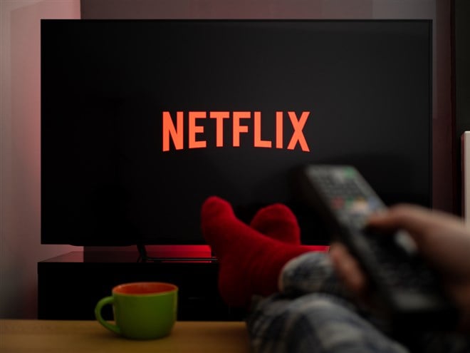 Someone with feet up watching Netflix on tv