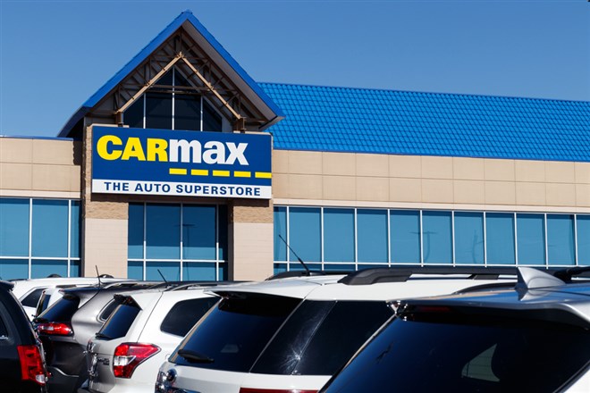 Photo of a CarMax storefront with cars parked outside. CarMax earnings reveal market headwinds.