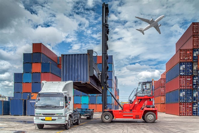 Photo of intermodal transport: a steel container being loaded onto a delivery truck, numerous steel containers in the background. JB Hunt Recent Earnings shows how Intermodal Ambitions Meet Market Challenges