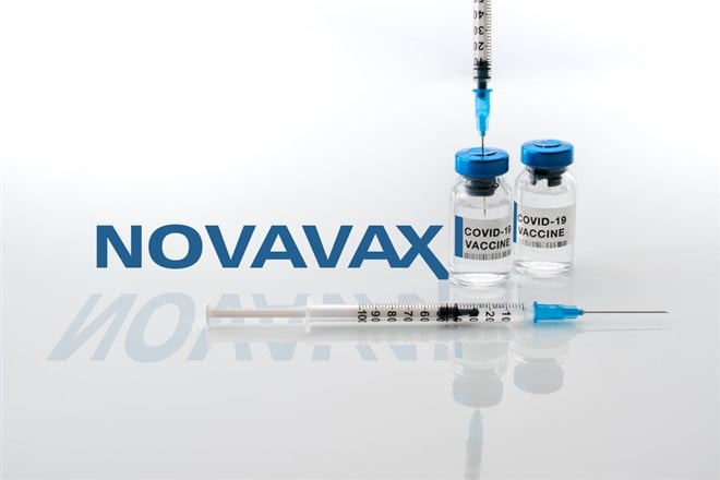 vials of covid-19 vaccine with syringes in the background Novavax Laboratory logo
