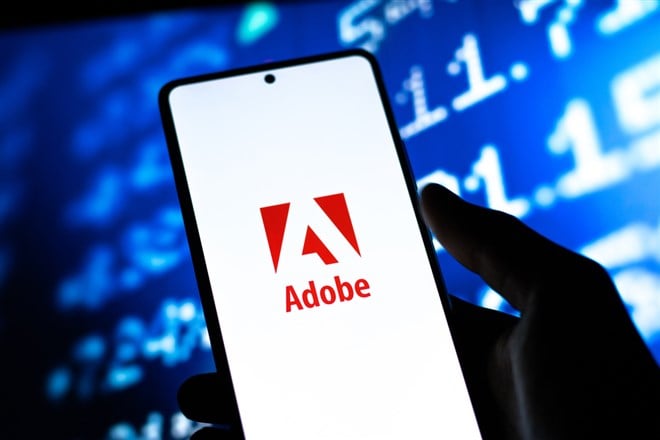 Adobe logo on smartphone screen with stock market background