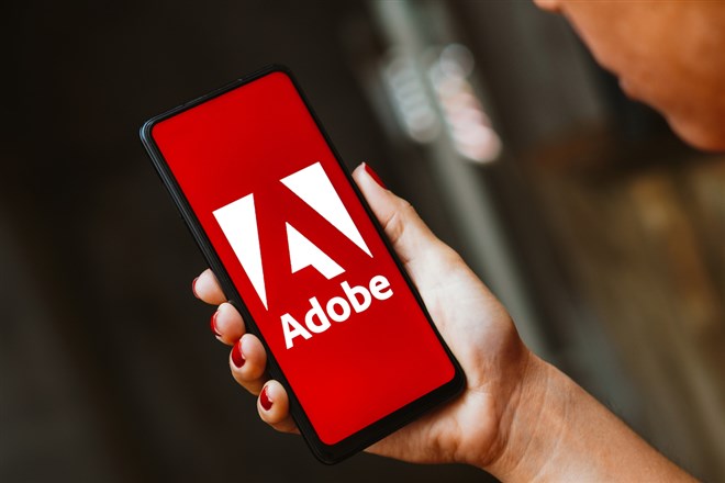 Adobe Inc. logo is displayed on a smartphone screen