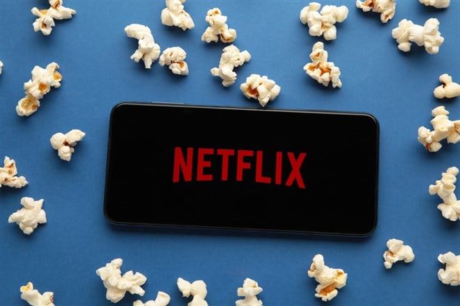 Smartphone with Netflix logo and popcorn on blue background