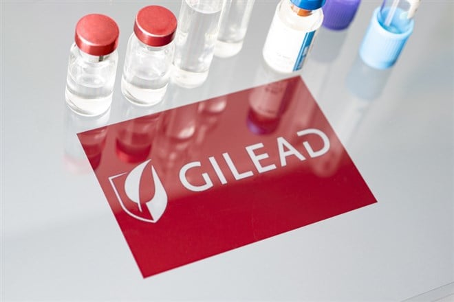 Vials of liquid on a white table and the logo of Gilead Sciences