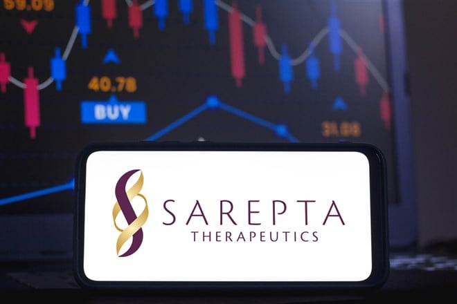 Sarepta Therapeutics logo seen displayed on a smartphone with the stock market graphic in the background