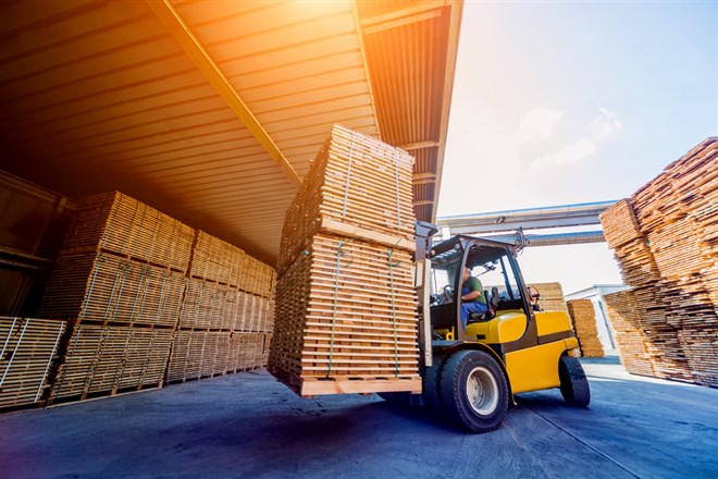 Forklift loader load lumber into a dry kiln. Wood drying in containers. Industrial concept