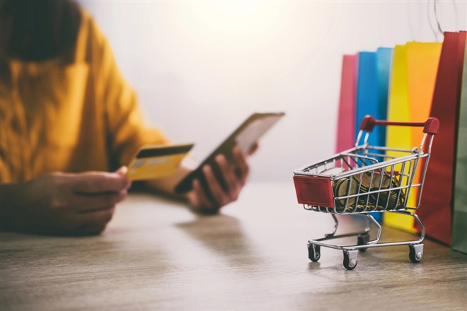 Image of Young woman using smartphone for online shopping