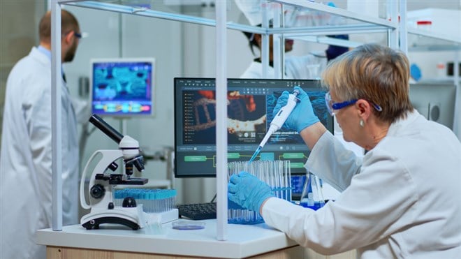 research scientist using micropipette filling test tubes