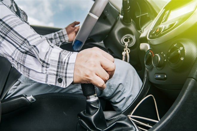 Close up of a man's hand on the gear lever of a car, concept of speed and gear lever, close up of hands accelerating on the gear lever