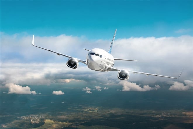 Passenger airplane fly in overcast clouds and blue sky