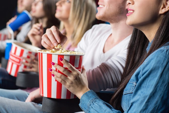 people eating popcorn in movie theater
