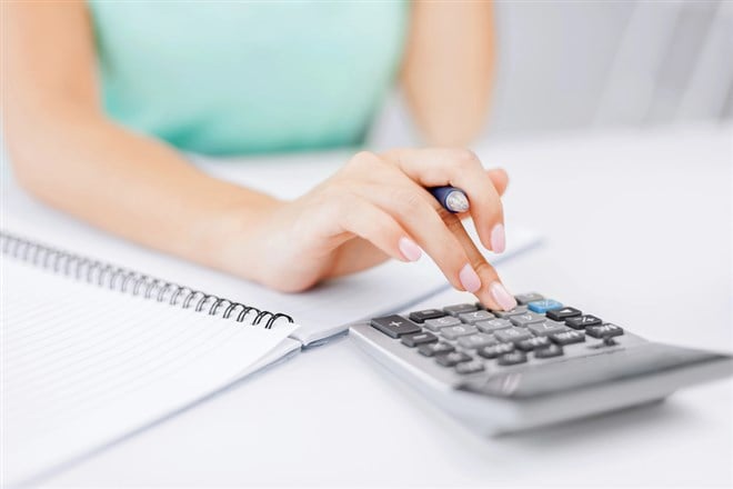 Photo of a woman inputing information into a calculator.