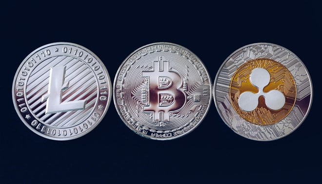 Photo of Bitcoin, litecoin and ripple coins currency finance money on graph chart background. Bitcoin as most important cryptocurrency concept. Stack of cryptocurrencies with a golden bitcoin in the middle.