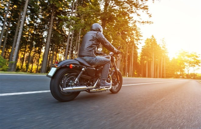 Back view of motorcycle driver on road - stock image