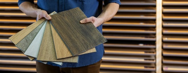 flooring store seller with vinyl floor samples in hands. copy space