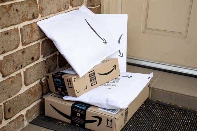 Amazon prime boxes and envelopes delivered to a front door of residential building