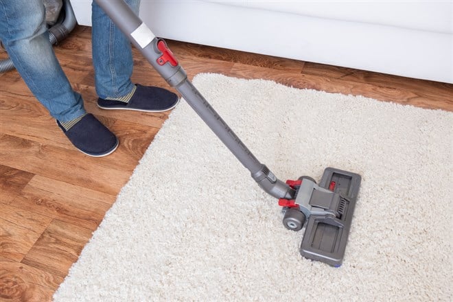 Vacuuming white carpet using the vacuum cleaner