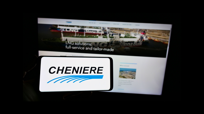 Person holding cellphone with logo of American LNG company Cheniere Energy Inc. on screen in front of business webpage