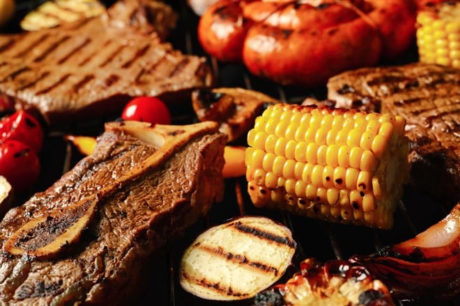 Fresh grilled meat steaks and vegetables on barbecue grate, closeup — Photo