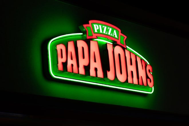 Papa John's lit exterior restaurant sign at night and trademark logo.