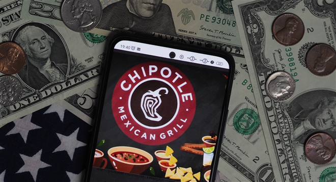 Chipotle Mexican Grill logo seen displayed on a smartphone with United States Dollar notes and coins in the background