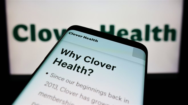 Mobile phone with website of healthcare company Clover Health Investments Corp. on screen in front of logo