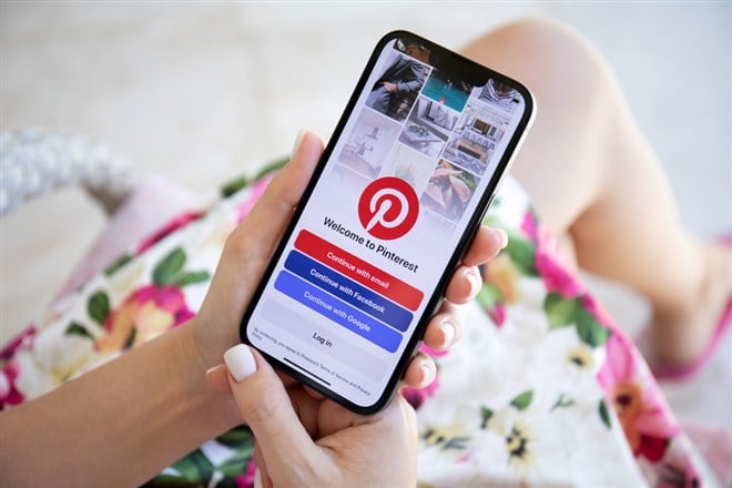 Alanya, Turkey - July 27, 2022: Woman hand holding Apple iPhone 13 with app Pinterest in the screen. iPhone 13 was created and developed by the Apple inc.