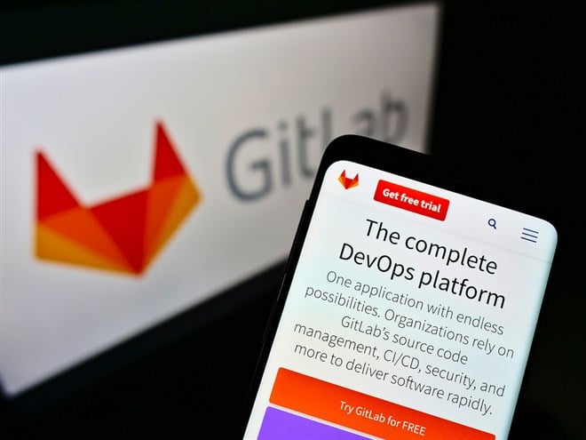 STUTTGART, GERMANY - Mar 03, 2021: Mobile phone with company website of American DevOps platform GitLab Inc. on screen in front of logo. Focus on center of cellphone display. - Stock Editorial Photography