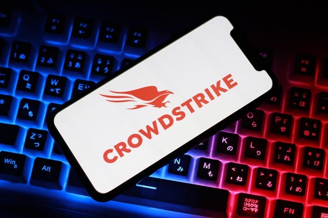 Close up view of the smartphone on neon keyboard with crowdstrike logo — Stock Editorial Photography