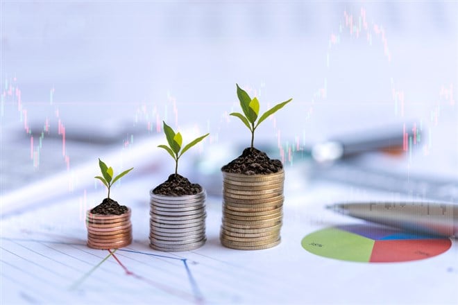 Growth plants economic on stack of coins on report paper analyze performance financial graph funding with calculate for investment business. Investment and Saving Concept