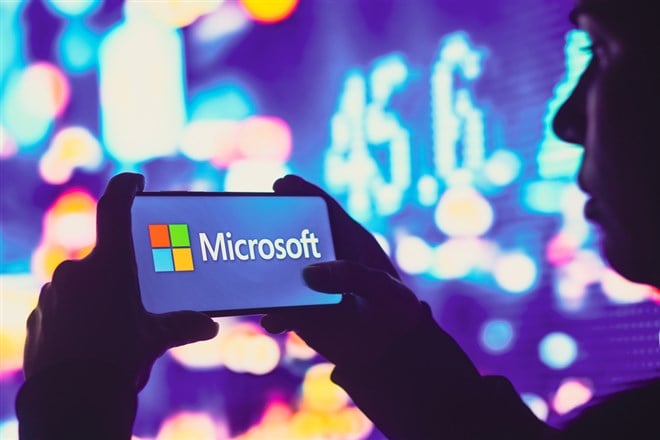 June 1, 2022, Brazil. In this photo illustration, a silhouetted woman holds a smartphone with the Microsoft Corporation logo displayed on the screen