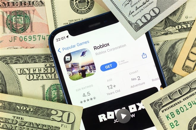 Kharkov, Ukraine - January 19, 2022: Roblox mobile game app and money background photo — Stock Editorial Photography