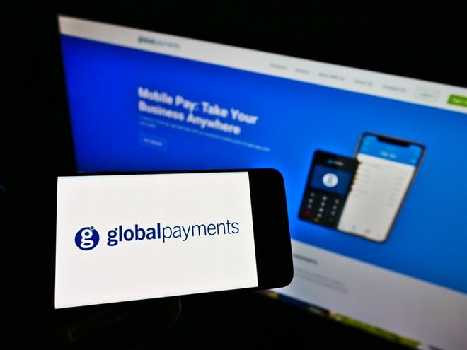 STUTTGART, GERMANY - Mar 14, 2021: Person holding cellphone with logo of American payment services provider Global Payments Inc. on screen in front of webpage. Focus on phone display. — Stock Editorial Photography