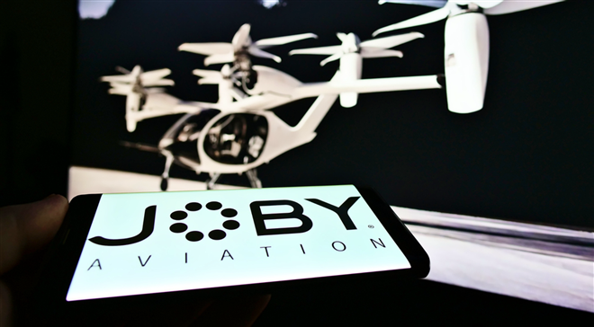 STUTTG, GERMANY - Jan 23, 2021: Person holding smartphone with logo of aerospace company Joby Aviation (air taxi) on screen. Focus on top center of phone display. — Stock Editorial Photography