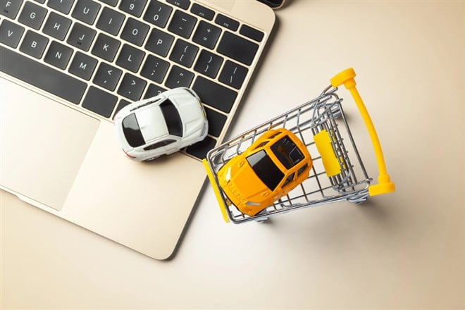 Online buying, selling car, toy car with laptop on gold table background, top view — Photo