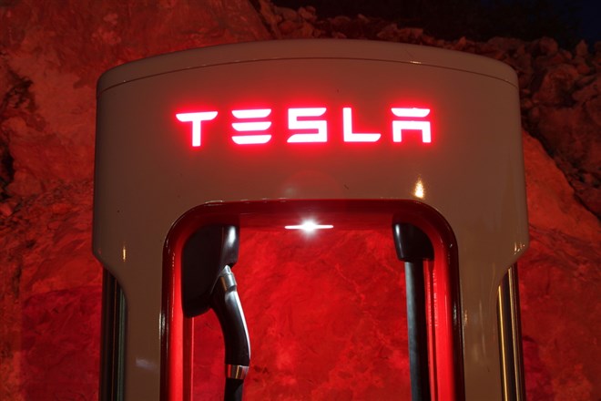 Tesla supercharger for electric cars at night - Stock Editorial Photography