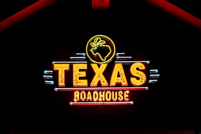 WOODBURY, MN, USA - DECEMBER 4, 2023: Texas Roadhouse restaurant exterior and trademark logo at night. - Stock Editorial Photography